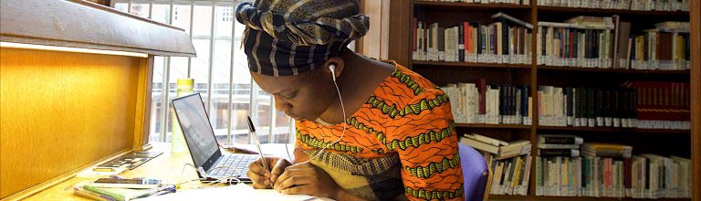 Student sat writing in study area 