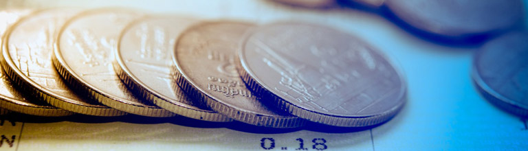 A fallen pile of coins on a financial document