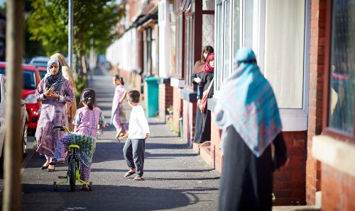 A family playing on a residential street.