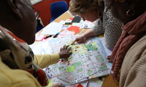 Three people looking at a map on a table.